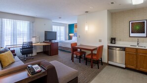 A hotel room with a living area, a kitchenette, a bed, and a TV. - Residence Inn by Marriott Rocky Mount (Rocky Mount)