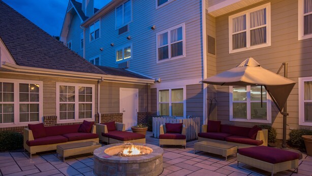 A patio area with a fire pit, outdoor furniture, and a large umbrella. - Residence Inn by Marriott Rocky Mount (Rocky Mount)
