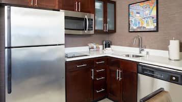 A modern kitchen with stainless steel appliances, wooden cabinets, and a dishwasher.