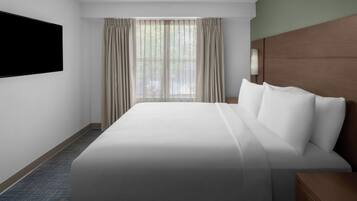 A hotel room with a large bed, a flat-screen TV mounted on the wall, and a window with curtains.