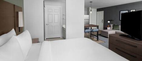 A hotel room with a large bed, a desk with two chairs, a television, and a wardrobe.