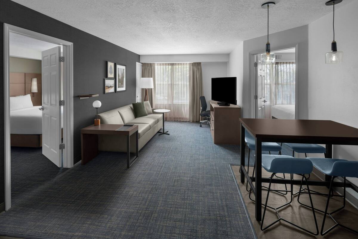 Une chambre d’hôtel avec un lit, un canapé, un bureau et une télévision.