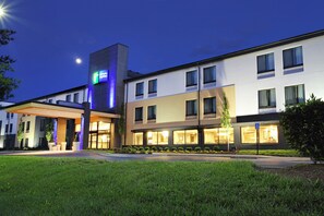A modern hotel with a prominent sign, multiple floors, and a well-lit entrance. - Holiday Inn Express Brentwood South - Cool Springs by IHG (Brentwood)