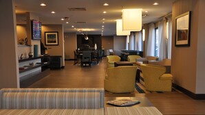 A hotel lobby with a reception desk, seating area, and a dining space. - Holiday Inn Express Brentwood South - Cool Springs by IHG (Brentwood)