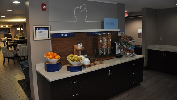 A hotel breakfast area with a fruit bowl, cereal, and coffee station. - Holiday Inn Express Brentwood South - Cool Springs by IHG (Brentwood)