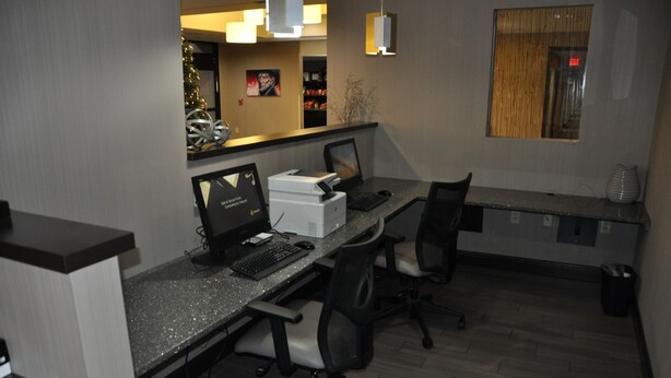 An office space with desks, computers, and chairs. There is a Christmas tree in the background. - Holiday Inn Express Brentwood South - Cool Springs by IHG (Brentwood)