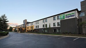 A Holiday Inn Express hotel with a modern design, featuring a parking lot and a clear sky. - Holiday Inn Express Brentwood South - Cool Springs by IHG (Brentwood)