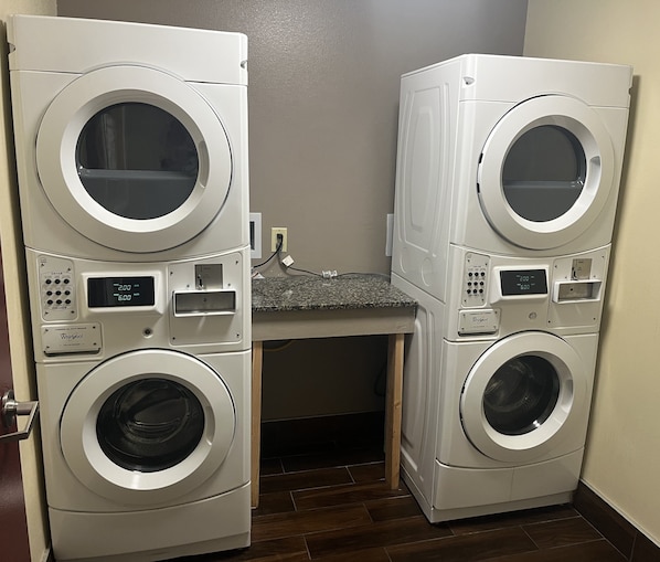 A laundry room with two stacked front-loading washers and dryers. - Red Roof Inn Murfreesboro (Murfreesboro)
