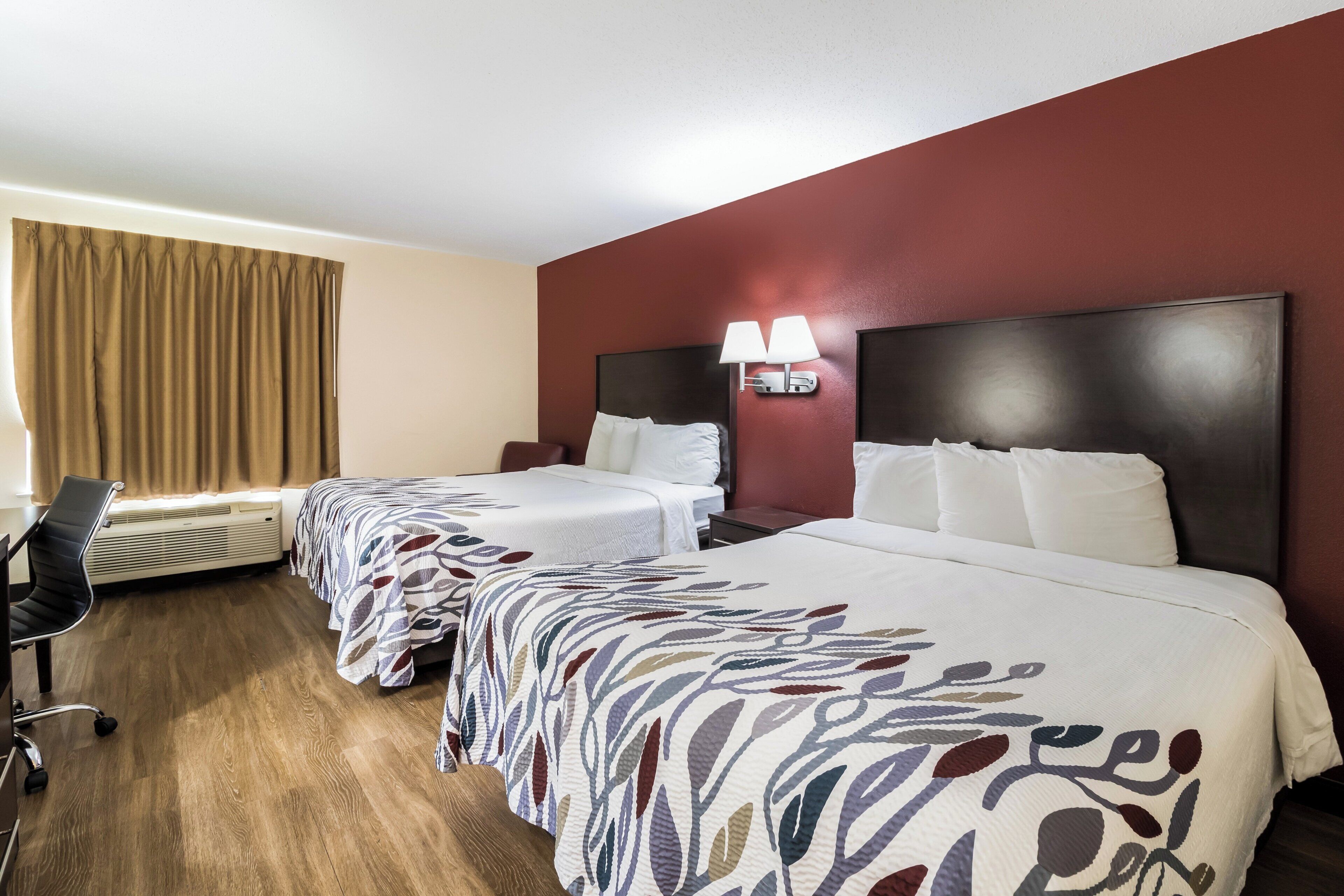 Una habitación de hotel con dos camas, un escritorio y una silla.
