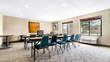 A conference room with a large table, chairs, a wooden cabinet, and a radiator.