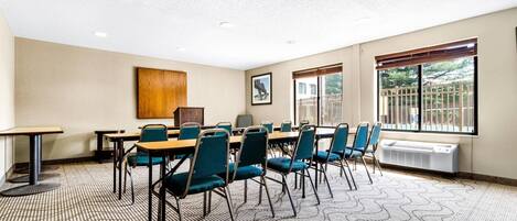 A conference room with a large table, chairs, a wooden cabinet, and a radiator.