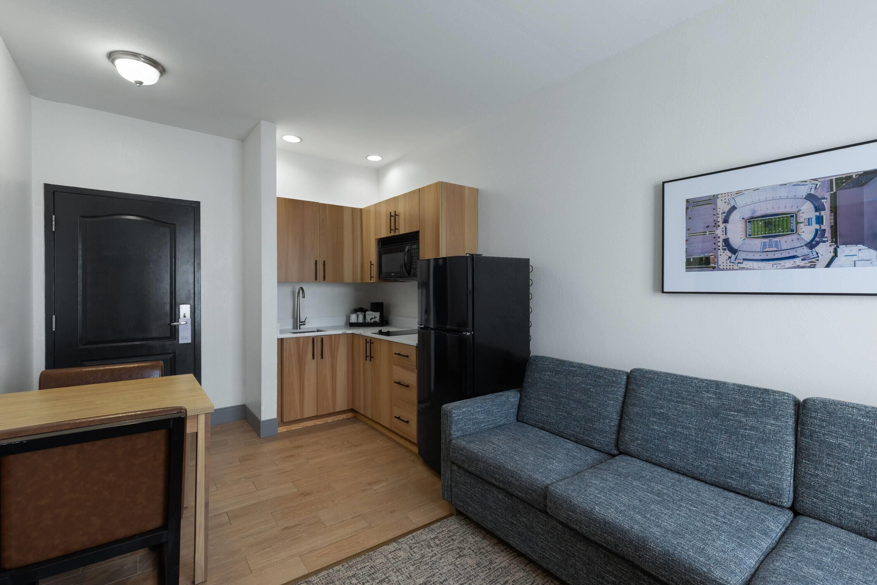 A compact living space with a kitchenette, a dining area, and a sofa.