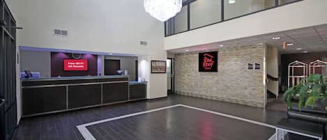 Un espace d’accueil d’hôtel doté d’un panneau numérique indiquant la disponibilité d’une connexion Wi-Fi gratuite.