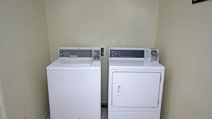 Two white front-loading washing machines in a corner with a tiled floor. - Red Roof Inn Gaffney (Gaffney)