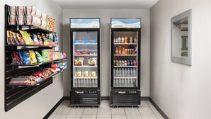 Deux distributeurs automatiques de boissons, chacun équipé d’étagères remplies de collations et de boissons.