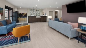 Un hall d’entrée moderne avec des canapés, un comptoir d’accueil et un distributeur automatique.