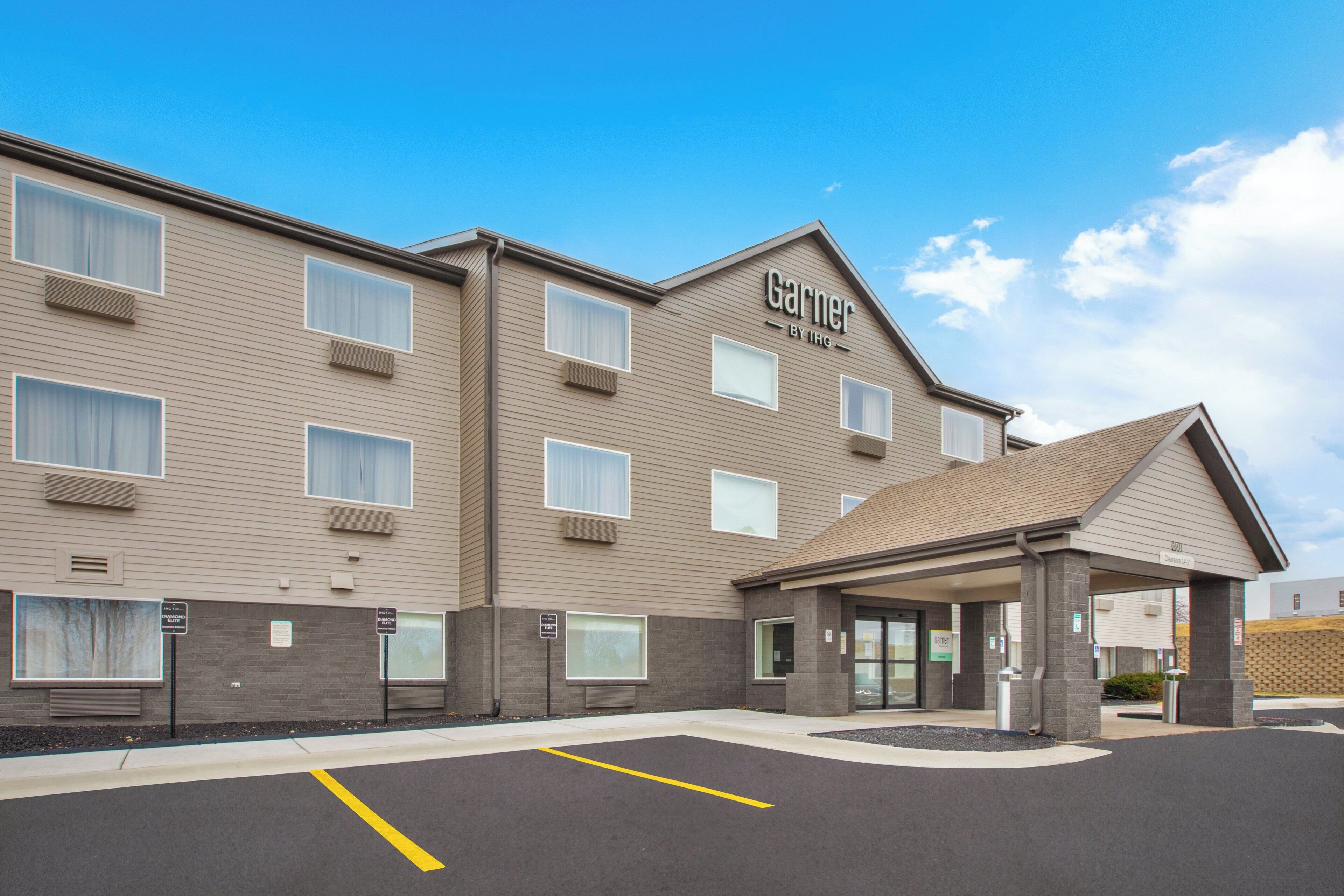 A hotel with a flat roof, multiple windows, and a covered entrance.