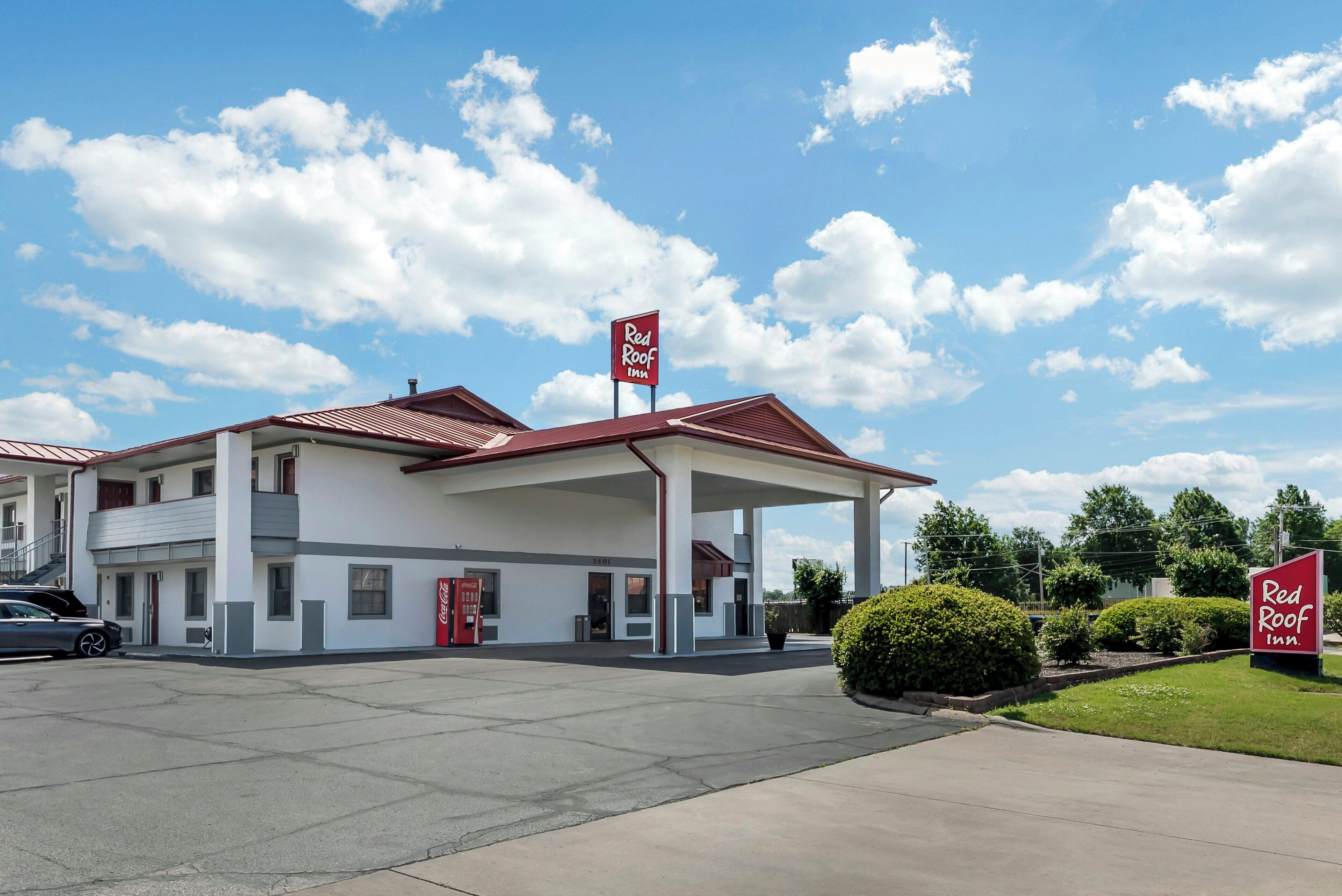A Red Roof Inn with a red roof, white walls, and a Coca-Cola sign.