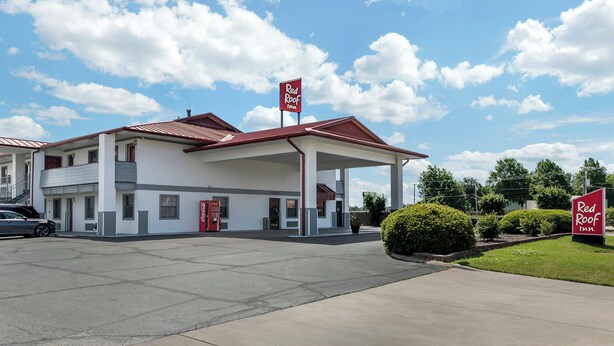 Et Red Roof Inn med rødt tag, hvide vægge og et Coca-Cola skilt.