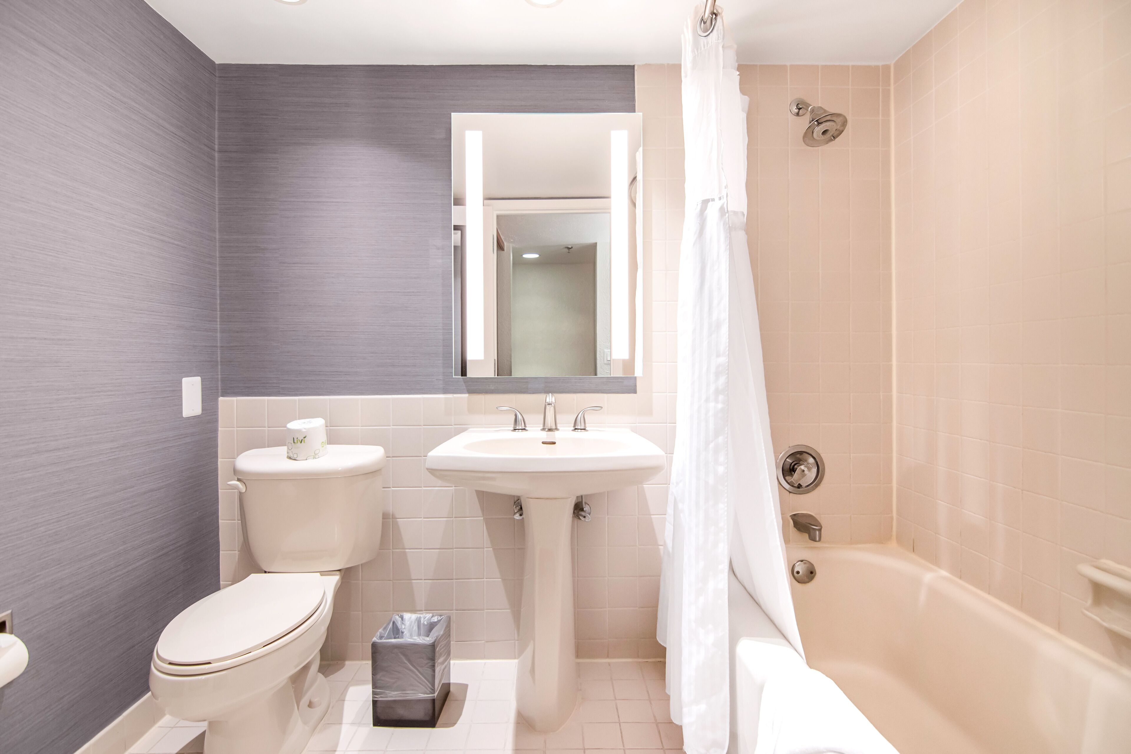 A modern bathroom with a toilet, sink, and bathtub.