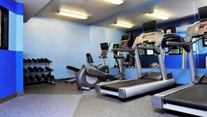 A gym with treadmills, elliptical machines, and a rack of dumbbells. - Four Points By Sheraton Portland East (Portland)