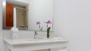 A bathroom with a white vanity, a large mirror, and a towel rack. - Four Points By Sheraton Portland East (Portland)