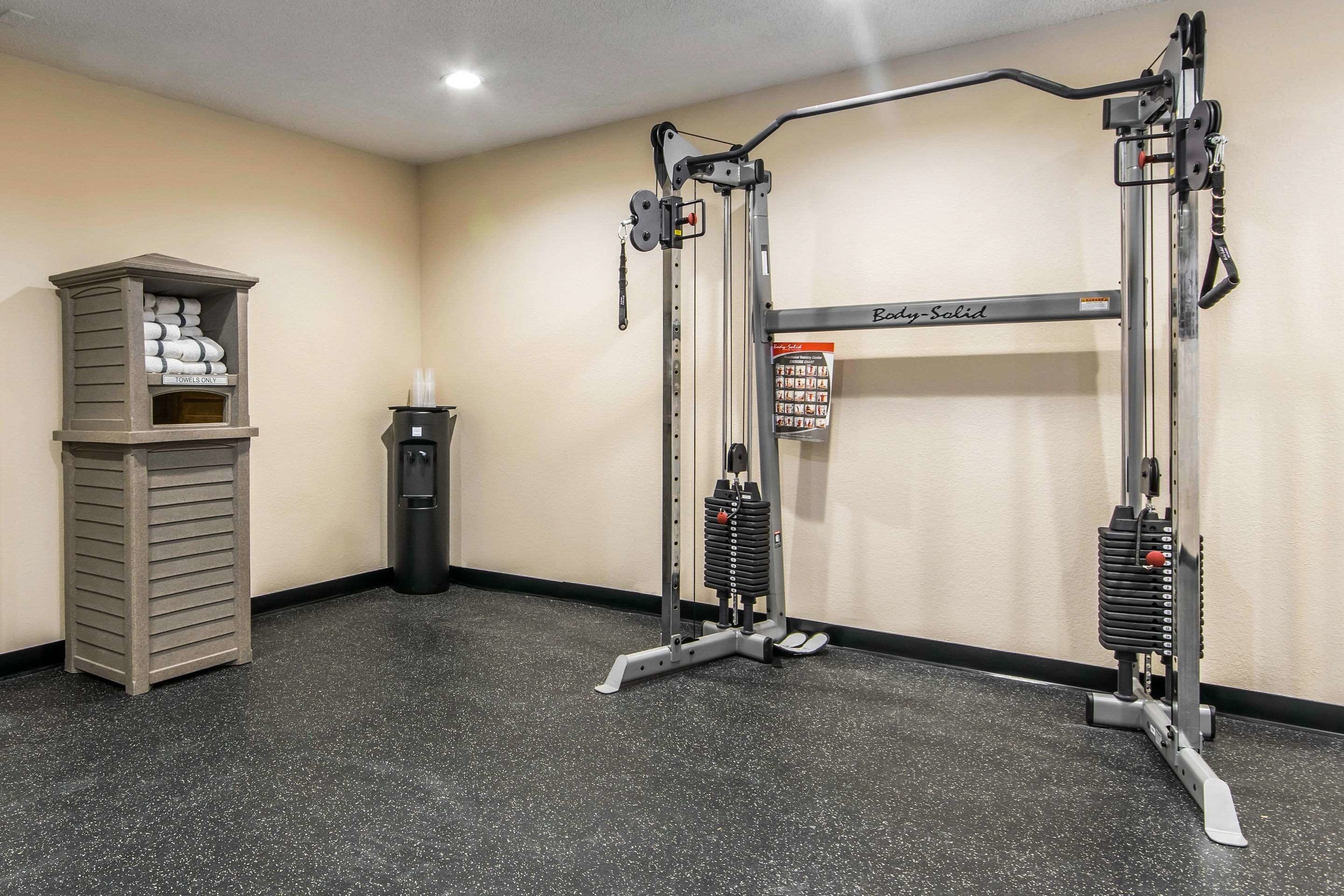 A gym with a pull-up bar, weight stack, and a towel rack.