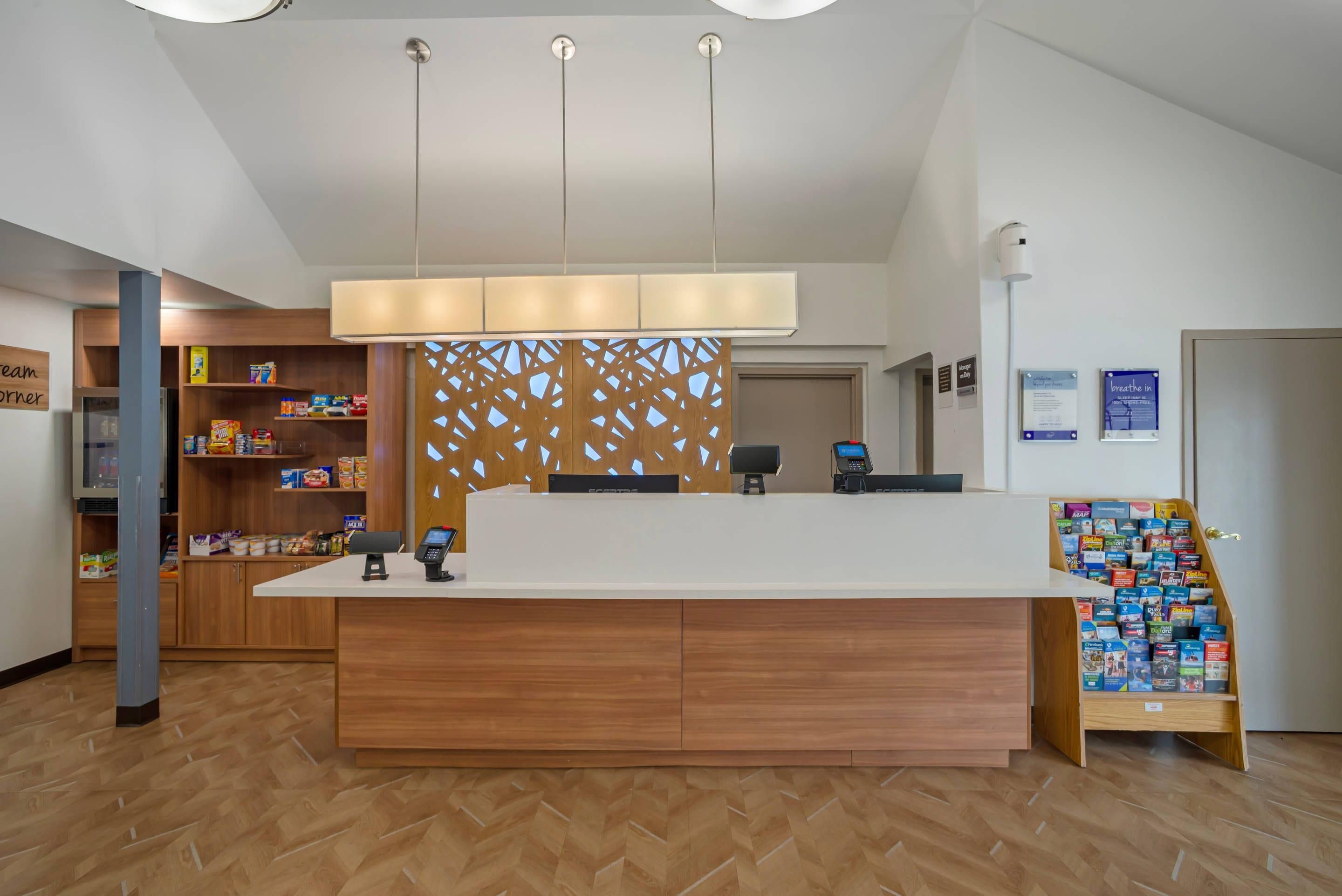 A reception desk with a wooden finish, a white counter, and a decorative panel with geometric cutouts.