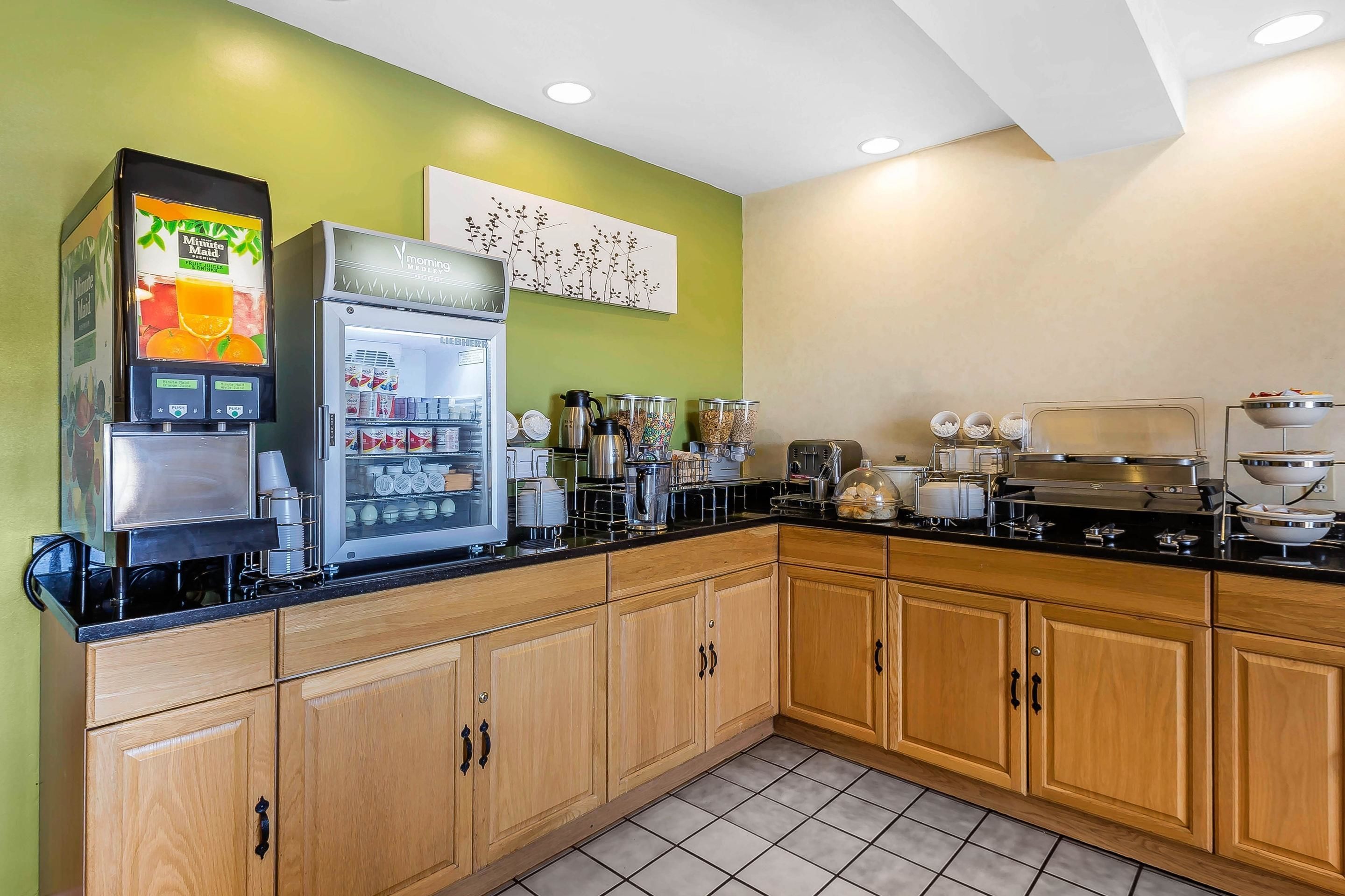 A kitchen with a coffee machine, refrigerator, and various appliances.