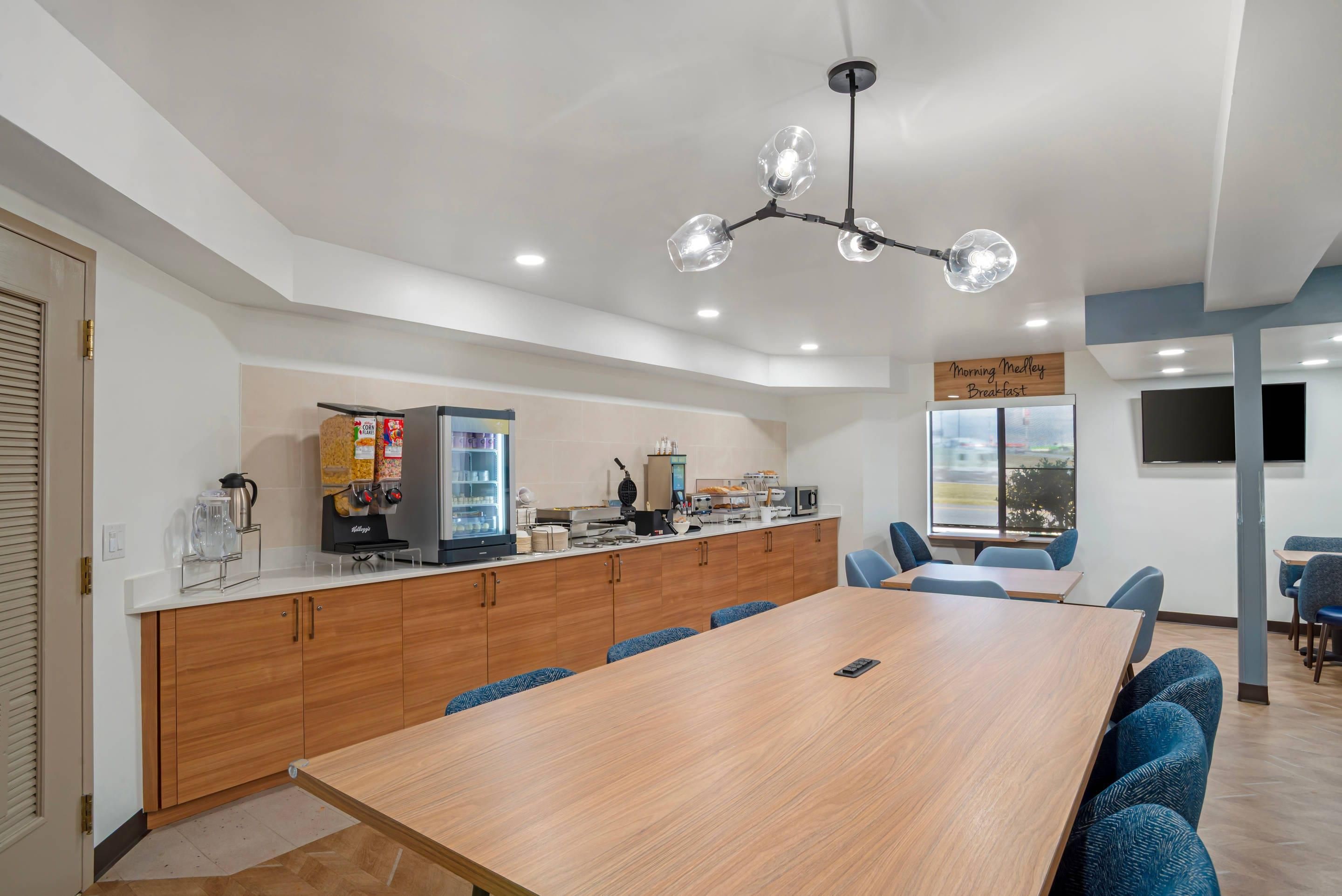 Una cocina moderna con encimera de madera, cafetera y refrigerador.