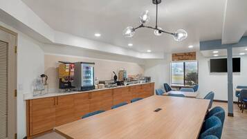 Una cocina moderna con encimera de madera, cafetera y refrigerador.