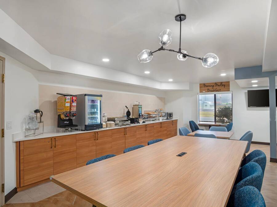 Una cocina moderna con encimera de madera, cafetera y refrigerador.