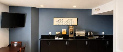 A compact kitchen with a flat-screen TV, a coffee machine, and a toaster.