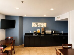 A compact kitchen with a flat-screen TV, a coffee machine, and a toaster. - Sleep Inn Woodbridge - Potomac Mills (Woodbridge)
