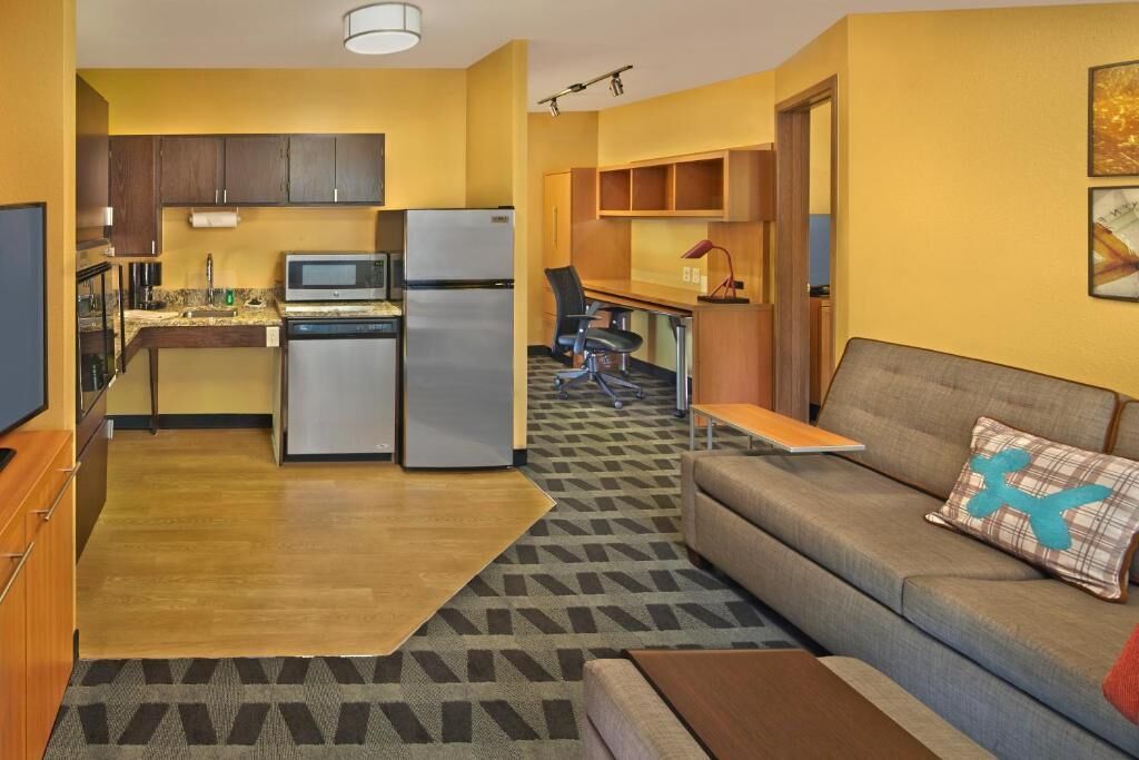 A compact living space with a kitchenette, a sofa, and a small dining table.