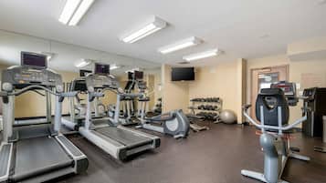 A gym with treadmills, elliptical machines, and free weights.