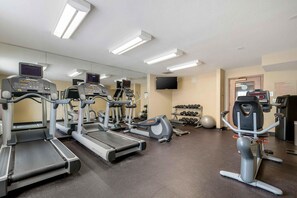 A gym with treadmills, elliptical machines, and free weights.