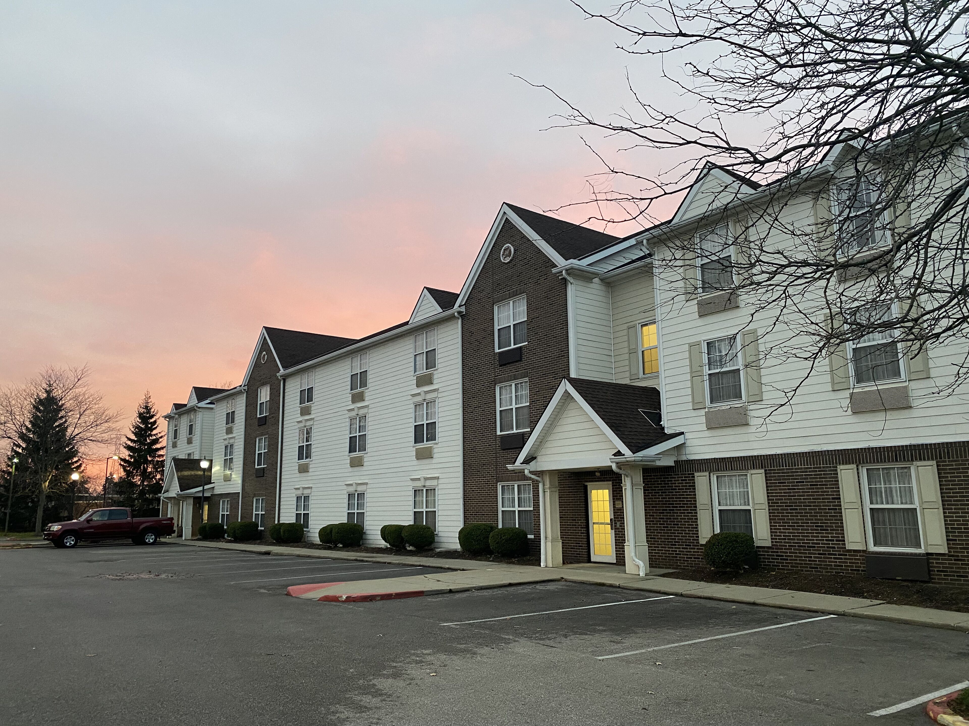 A row of multi-story buildings with a parking lot in front.