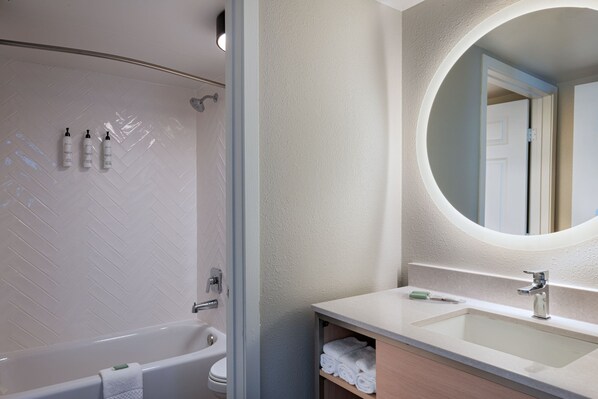 Une salle de bain moderne avec une baignoire, un lavabo et un miroir.