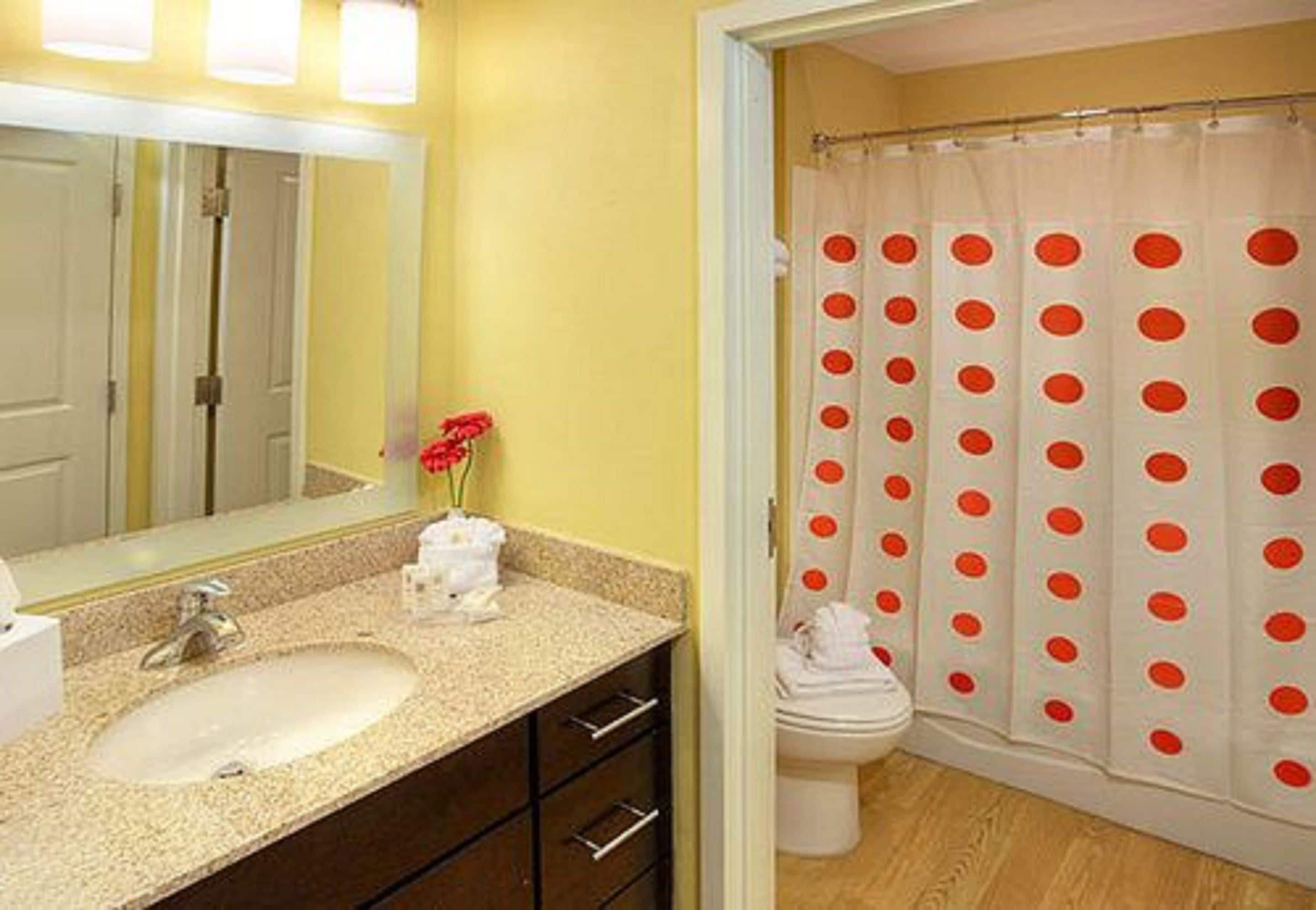 A bathroom with a sink, mirror, and toilet.