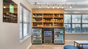 A MainStay MARKETPLACE with refrigerated display cases and shelves stocked with snacks and beverages. - MainStay Suites Houston NASA/Clear Lake (Houston)