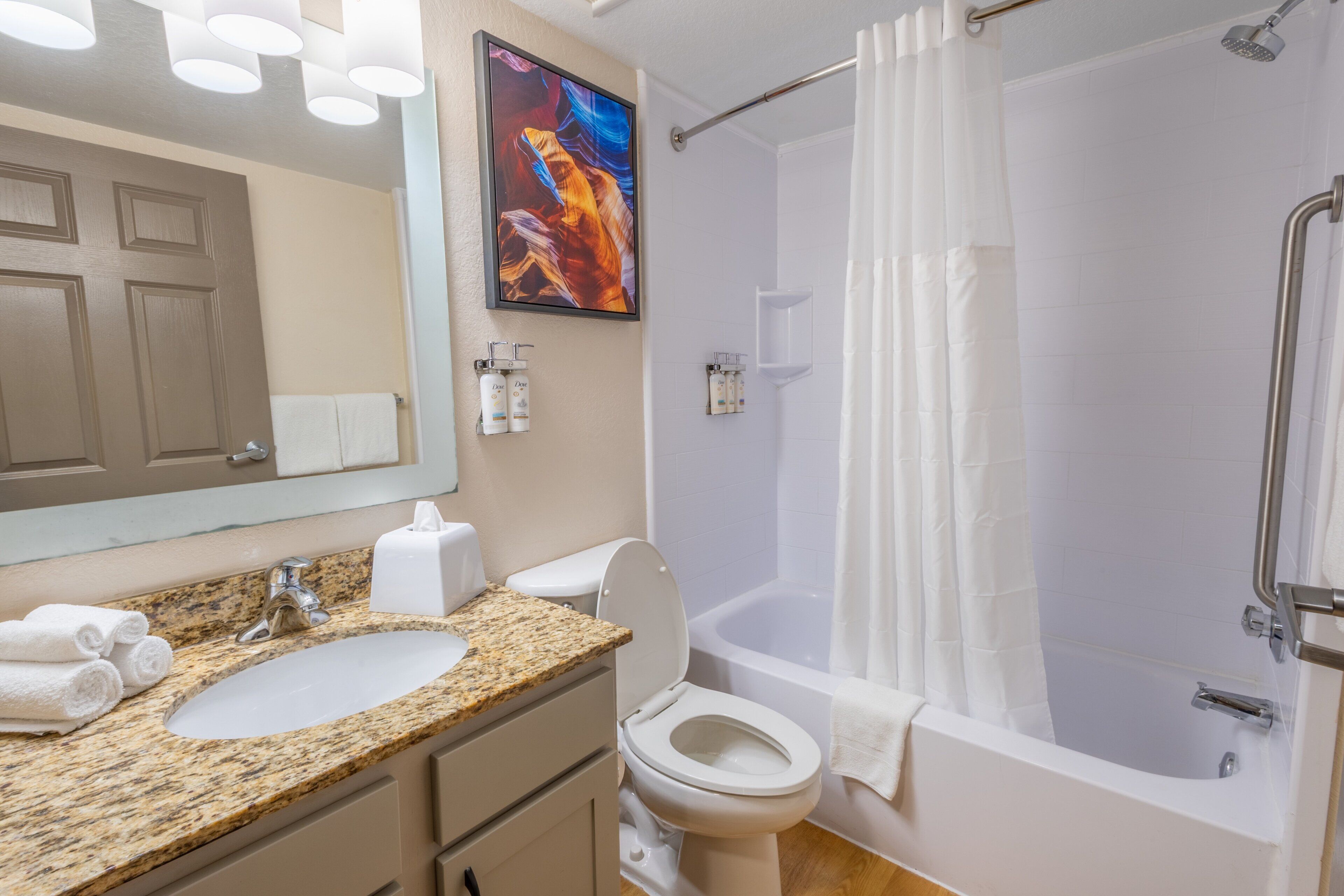 A bathroom with a sink, toilet, and shower.