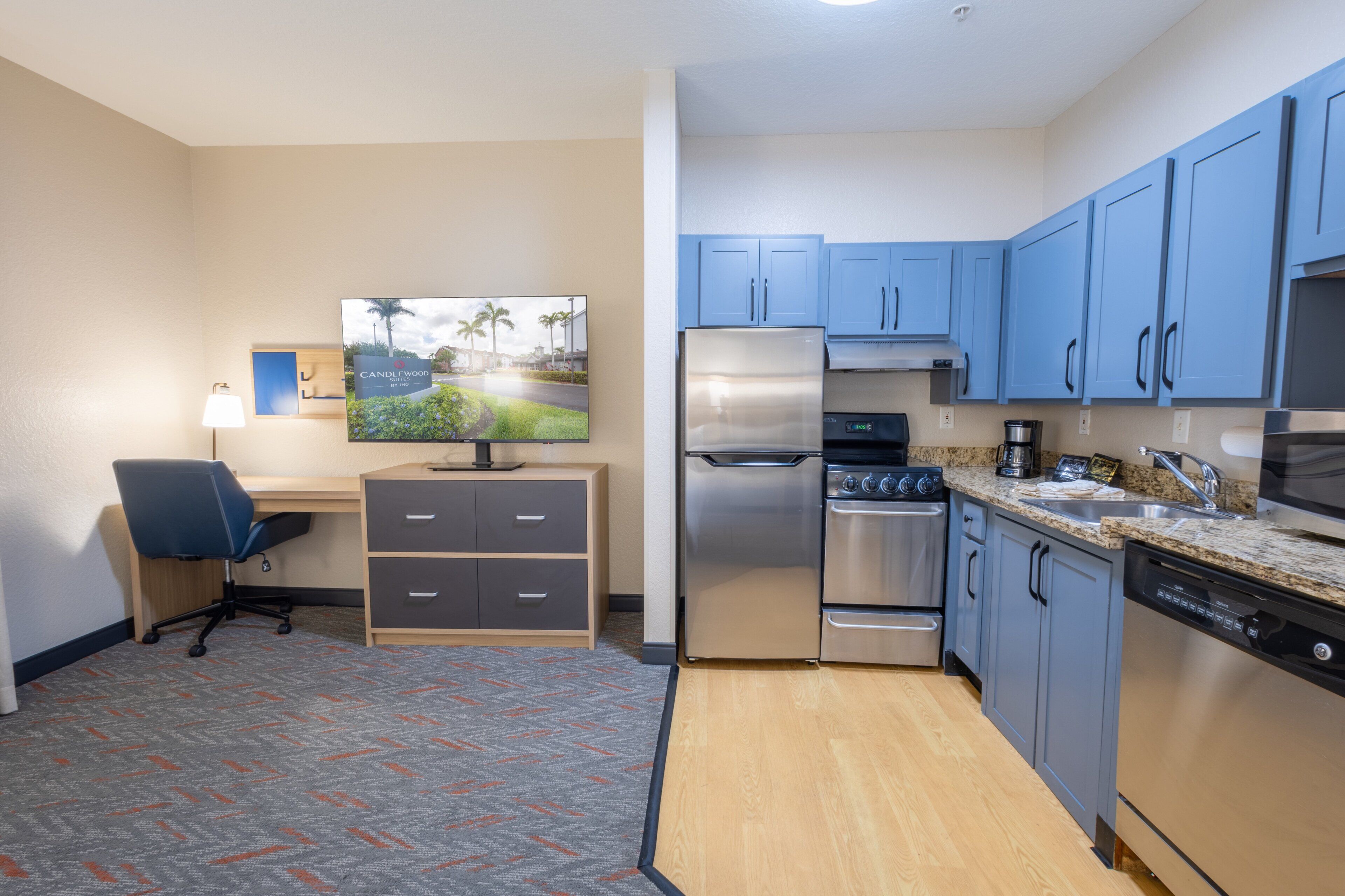A compact kitchen with a refrigerator, stove, microwave, and dishwasher.