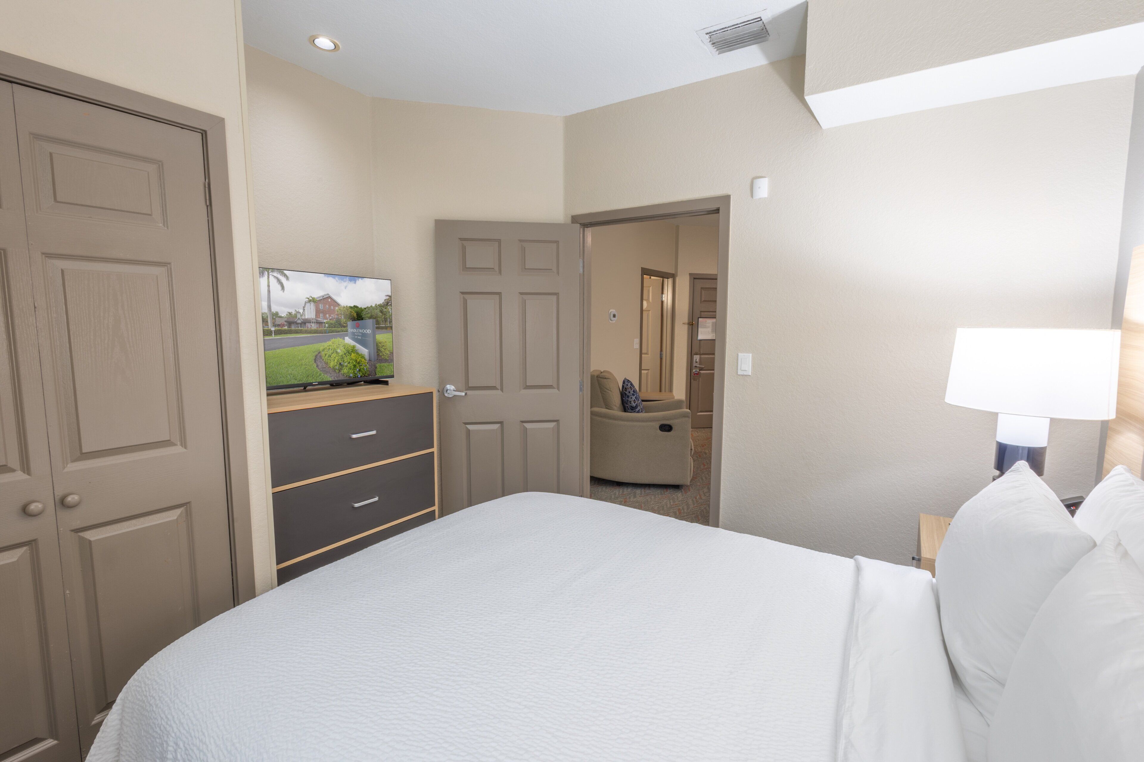 Habitació d'hotel amb un llit, una televisió, una taula i una cadira.