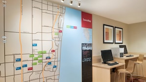 A map with various locations and amenities, a desk with computers, and framed pictures on the wall.