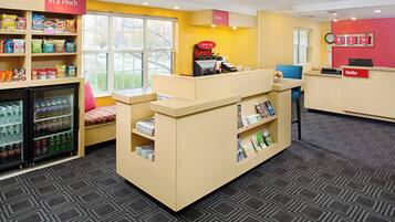 A reception area with a counter, seating, and vending machines.