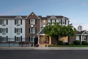A multi-story residential building with a brick facade, a gated entrance, and a small pool area. - TownePlace Suites by Marriott Salt Lake City Layton (Layton)