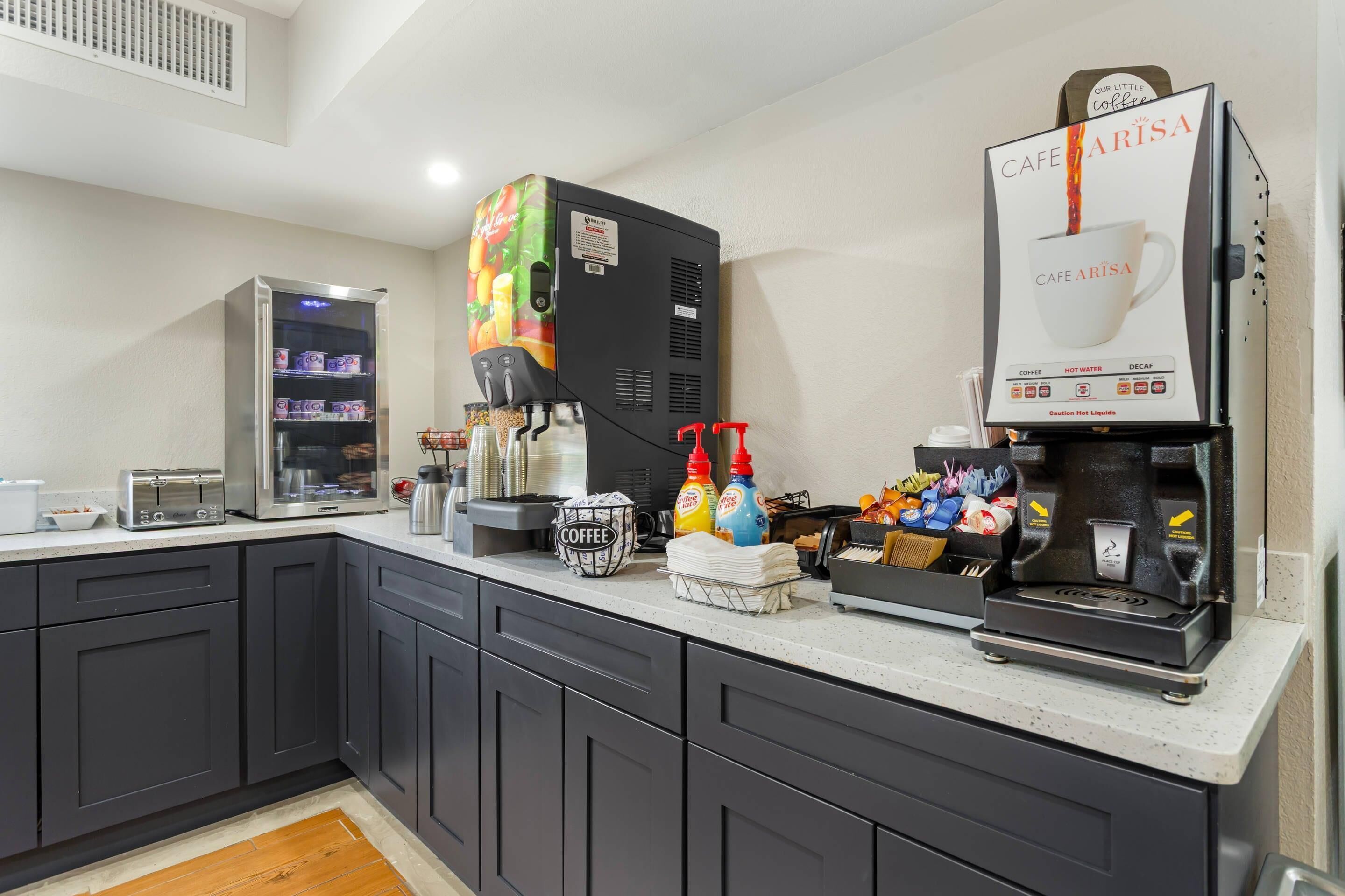 Una cocina moderna con estación de café, que incluye una cafetera, un microondas y diversos accesorios para preparar café.