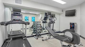 A gym with treadmills, a weight bench, and various exercise equipment.