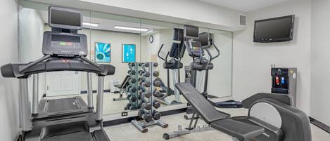 A gym with treadmills, a weight bench, and various exercise equipment.